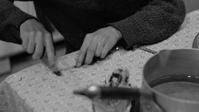 Wide shot frame from In the Mouth of Madness — sitting, table, kitchen