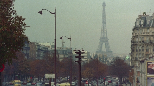 Wide shot frame from In the Mouth of Madness — walking, street, tower