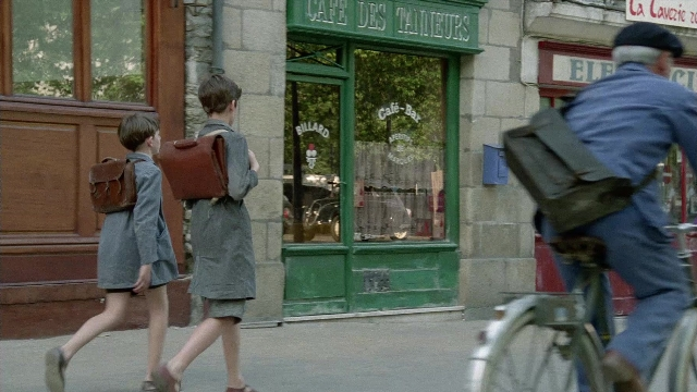 Wide shot frame from In the Mouth of Madness — walking, street, coat