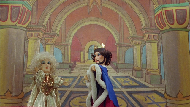 Wide shot frame from In the Mouth of Madness — standing, room, hand