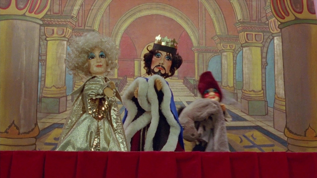 Wide shot frame from In the Mouth of Madness — hat, coat, dress