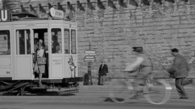 Wide shot frame from In the Mouth of Madness — sitting, standing, walking