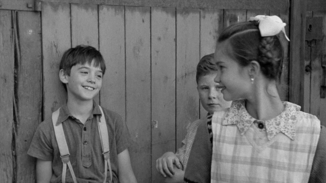 Wide shot frame from In the Mouth of Madness — standing, shirt, face