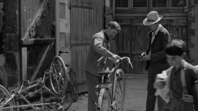 Wide shot frame from In the Mouth of Madness — sitting, standing, plate