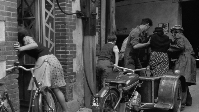 Wide shot frame from In the Mouth of Madness — standing, plate, door