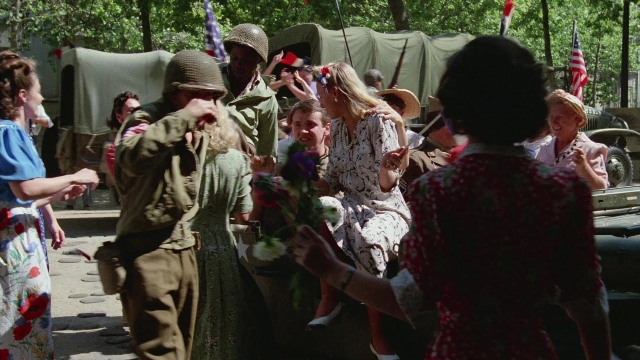 Wide shot frame from In the Mouth of Madness — standing, dialogue, street