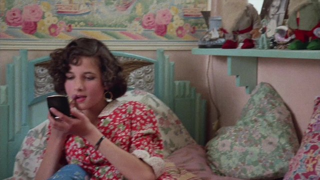 Wide shot frame from In the Mouth of Madness — sitting, bed, phone