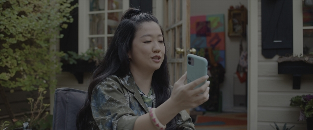 Wide shot frame from Joy Ride — sitting, phone, door