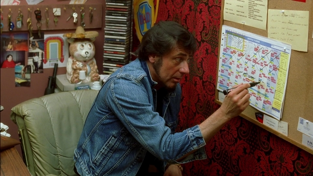 Wide shot frame from Kill Bill: Vol. 2 — sitting, book, room