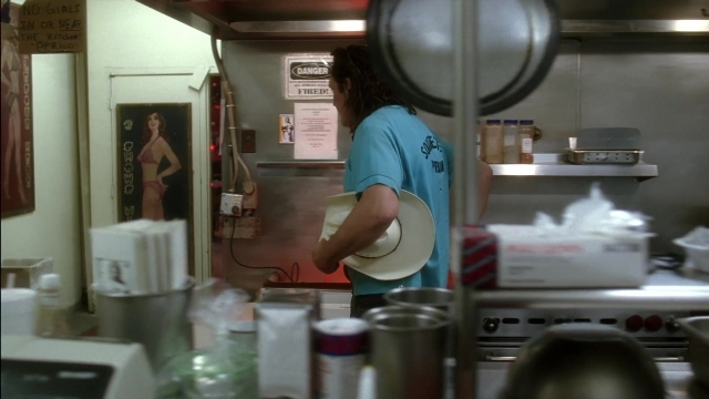 Wide shot frame from Kill Bill: Vol. 2 — standing, hat, kitchen