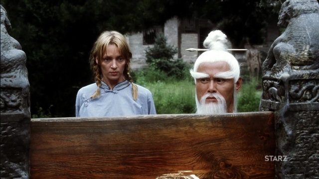 Wide shot frame from Kill Bill: Vol. 2 — standing, dress, beard
