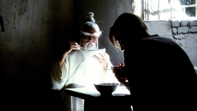Wide shot frame from Kill Bill: Vol. 2 — sitting, room, table