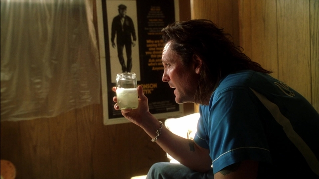 Wide shot frame from Kill Bill: Vol. 2 — sitting, room, hand