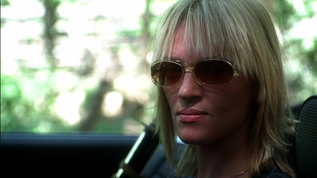 Close-up frame from Kill Bill: Vol. 2 — sitting, car, face