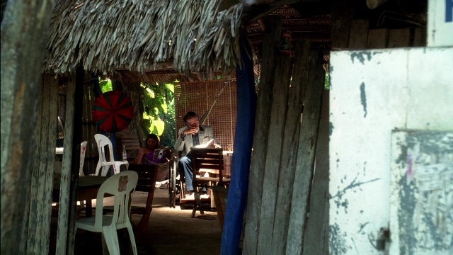 Wide shot frame from Kill Bill: Vol. 2 — sitting, book, table