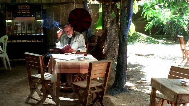 Wide shot frame from Kill Bill: Vol. 2 — sitting, book, table