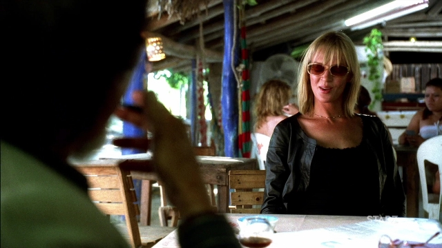 Wide shot frame from Kill Bill: Vol. 2 — sitting, table, bottle