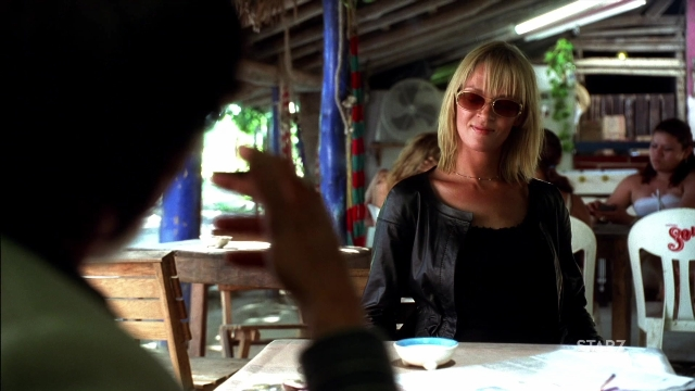 Wide shot frame from Kill Bill: Vol. 2 — sitting, table, hand