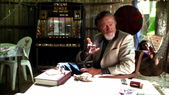 Wide shot frame from Kill Bill: Vol. 2 — sitting, book, room