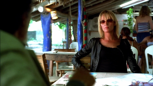 Wide shot frame from Kill Bill: Vol. 2 — sitting, table, jacket