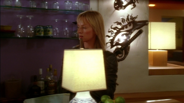 Wide shot frame from Kill Bill: Vol. 2 — standing, room, table