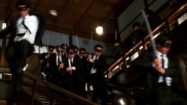 Wide shot frame from Kill Bill: Vol. 2 — standing, suit, fight