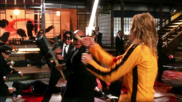 Wide shot frame from Kill Bill: Vol. 2 — standing, room, suit