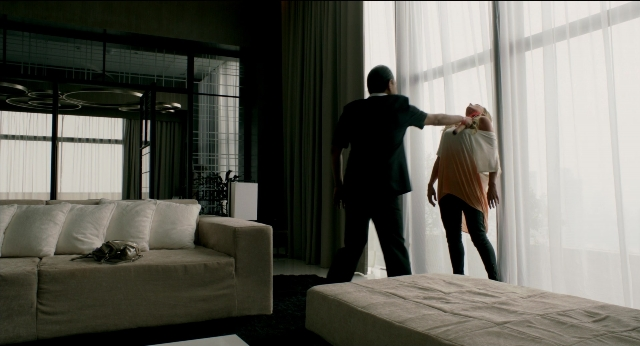 Medium shot frame from Only God Forgives — standing, room, table