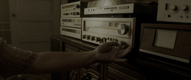 Wide shot frame from The Conjuring: The Devil Made Me Do It — room, door, hand