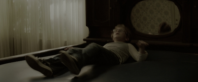 Wide shot frame from The Conjuring: The Devil Made Me Do It — room, bed, mirror