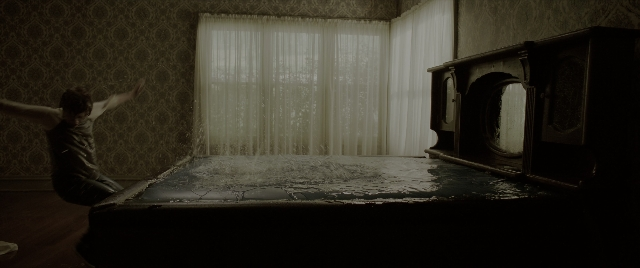 Wide shot frame from The Conjuring: The Devil Made Me Do It — sitting, room, bed