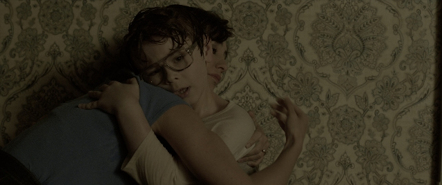Wide shot frame from The Conjuring: The Devil Made Me Do It — bed, hug, hair