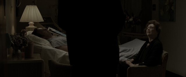 Wide shot frame from The Conjuring: The Devil Made Me Do It — sitting, room, table