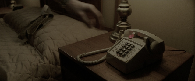 Wide shot frame from The Conjuring: The Devil Made Me Do It — room, bed, phone