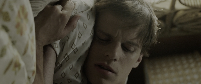 Close-up frame from The Conjuring: The Devil Made Me Do It — bed, hand, bedroom
