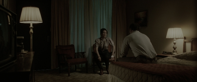 Wide shot frame from The Conjuring: The Devil Made Me Do It — sitting, room, bed