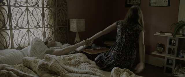 Wide shot frame from The Conjuring: The Devil Made Me Do It — standing, room, table