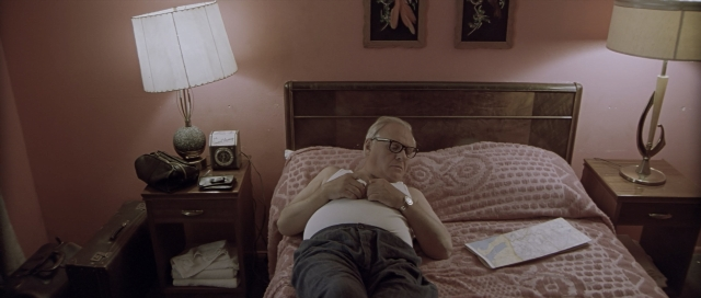 Wide shot frame from The World's Fastest Indian — bed, shirt, bedroom