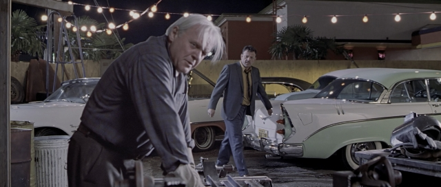 Wide shot frame from The World's Fastest Indian — dialogue, car, suit