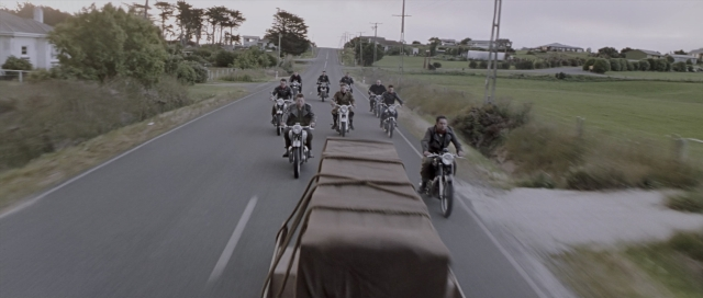 Wide shot frame from The World's Fastest Indian — street, car, bicycle