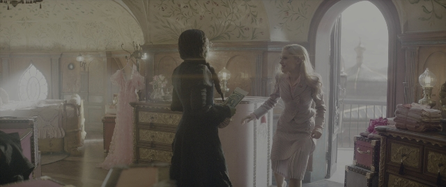Wide shot frame from Wicked: Part I — book, standing, room