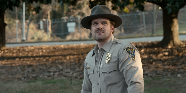 Wide shot frame from Stranger Things — standing, hat, uniform