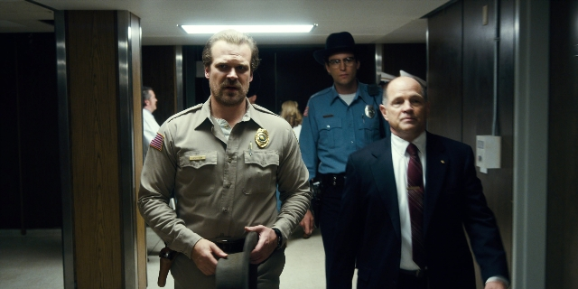 Wide shot frame from Stranger Things — walking, hat, uniform
