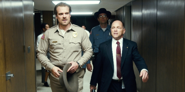Wide shot frame from Stranger Things — walking, hat, uniform