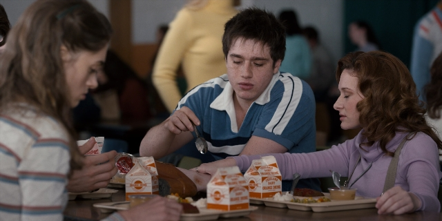 Wide shot frame from Stranger Things — sitting, plate, table