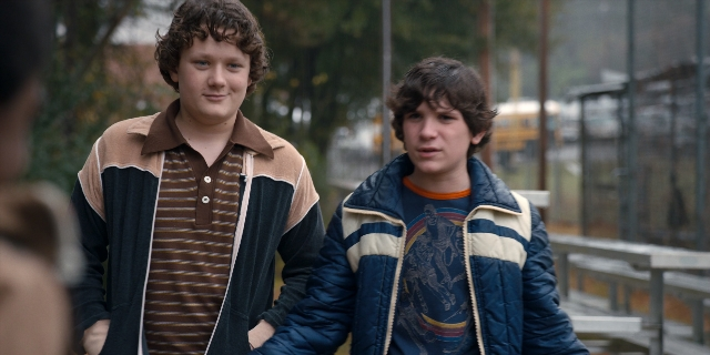Wide shot frame from Stranger Things — standing, shirt, jacket