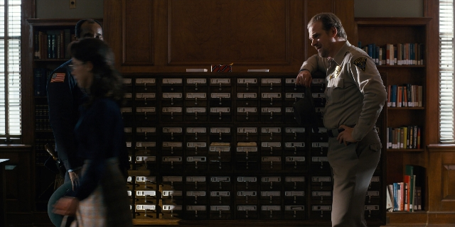 Wide shot frame from Stranger Things — book, standing, room