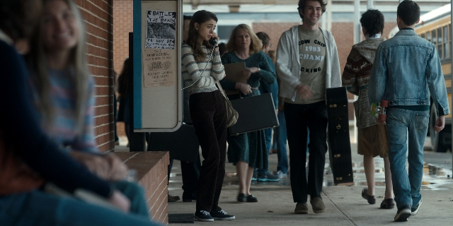 Wide shot frame from Stranger Things — sitting, walking, dialogue