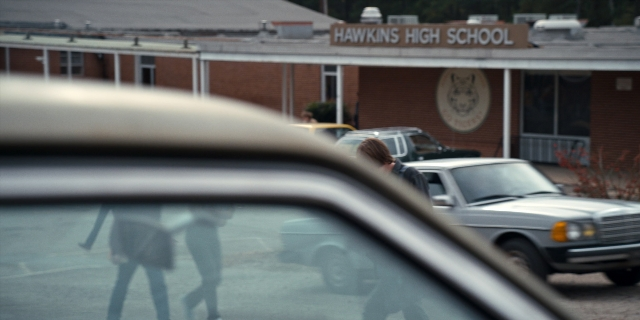 Frame from Stranger Things — walking, street, car