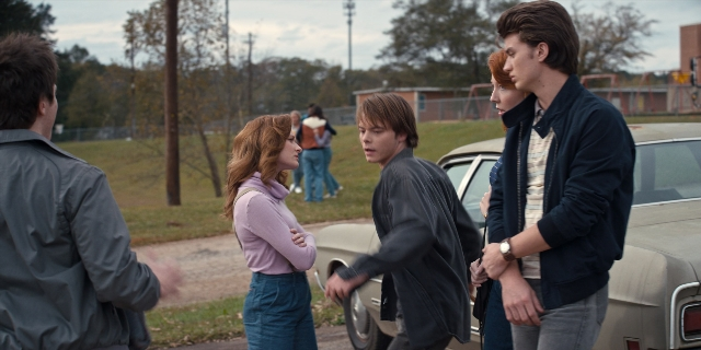 Wide shot frame from Stranger Things — standing, dialogue, street